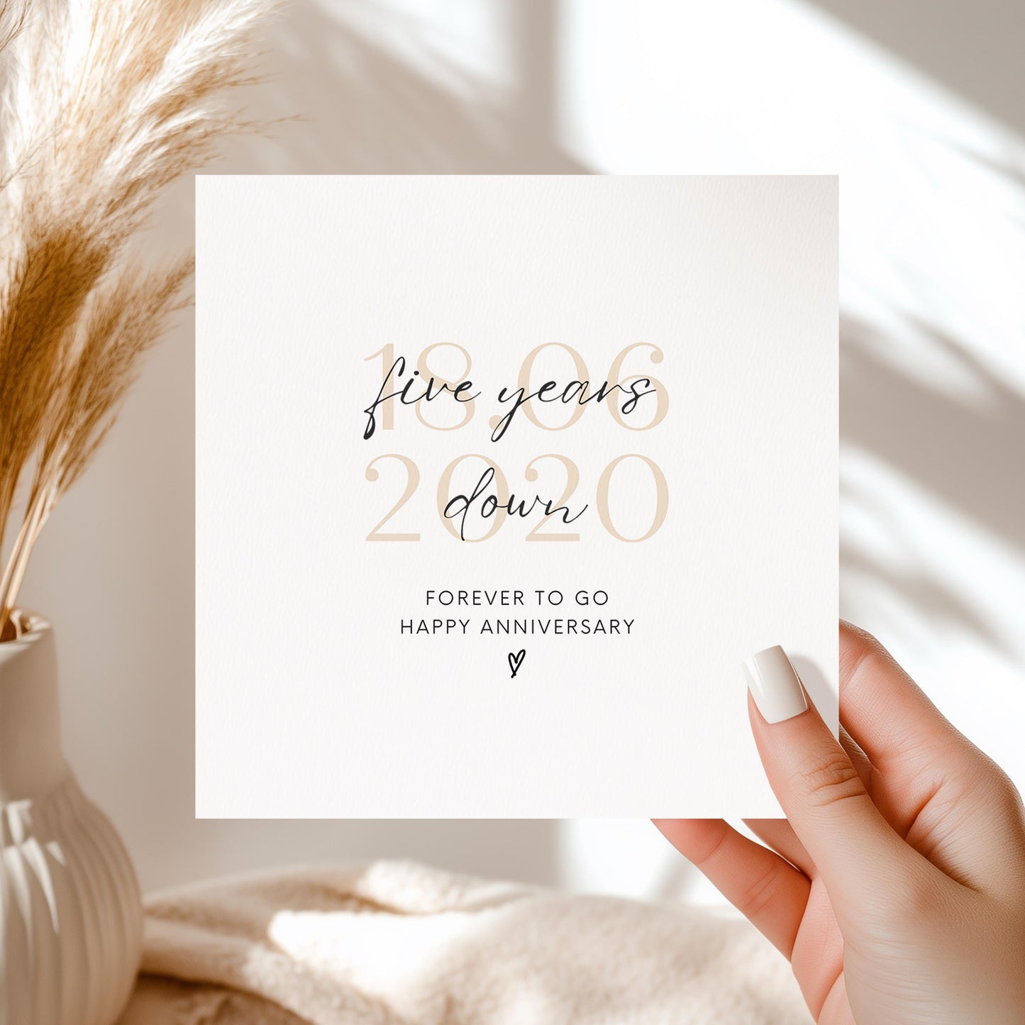 Minimalist five-year anniversary card featuring soft beige date, script text reading “Five Years Down”, and a small heart detail.