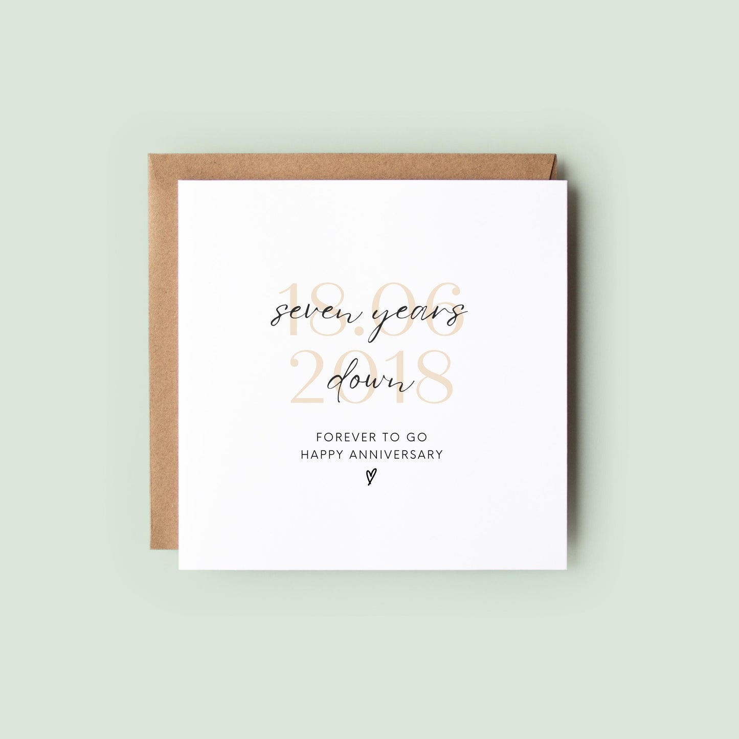 Personalised seven-year anniversary card featuring soft beige date, script text reading “Seven Years Down”, and a small heart detail.