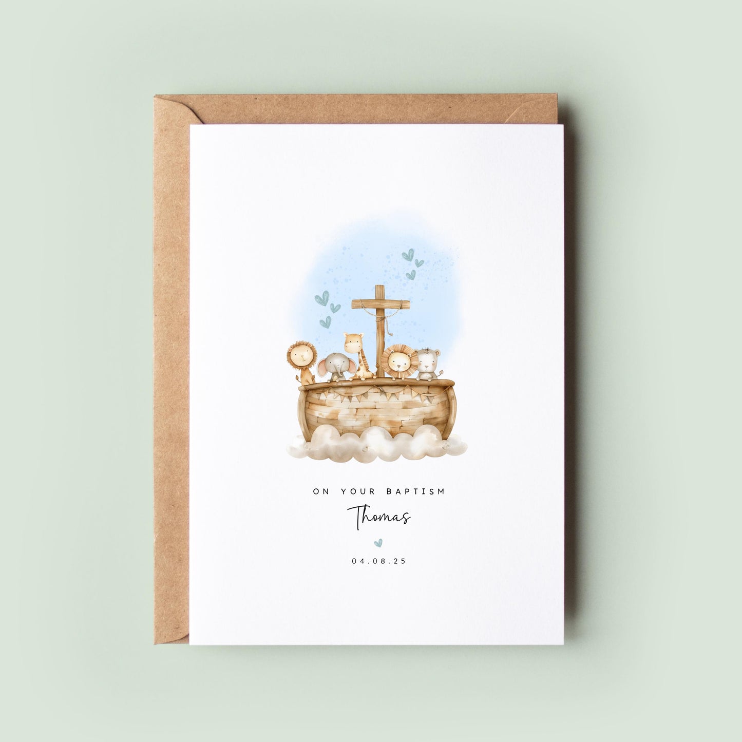 Personalised baptism card featuring a wooden ark with animals, including lions, elephants, and a giraffe, with a cross on top. Soft blue hearts are in the background. Text reads “On your Baptism,” followed by the name and date.