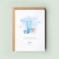 Personalised baptism card featuring a large blue letter “J” with a teddy bear sitting on a cloud. The text reads “To a special boy on your baptism day,” followed by the name “Joshua” and date. Comes with a recycled kraft envelope.