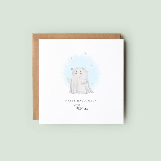 Cute Halloween card with a smiling cartoon ghost and soft blue watercolour stars, featuring the message “Happy Halloween” with a personalised name underneath